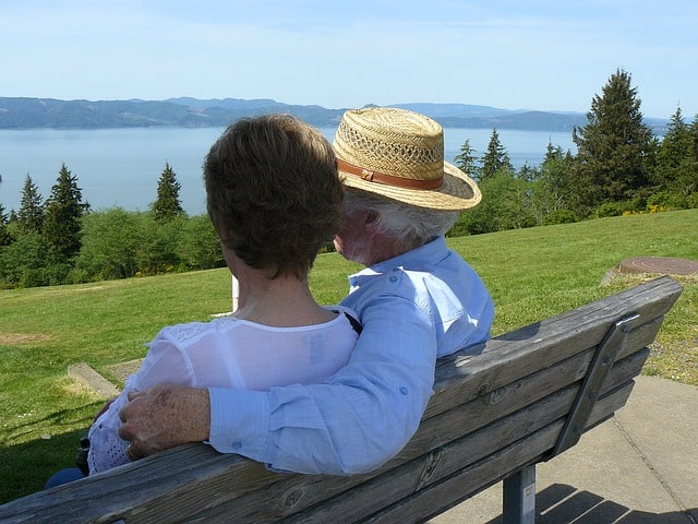 An older couple on a park bench enjoying the view