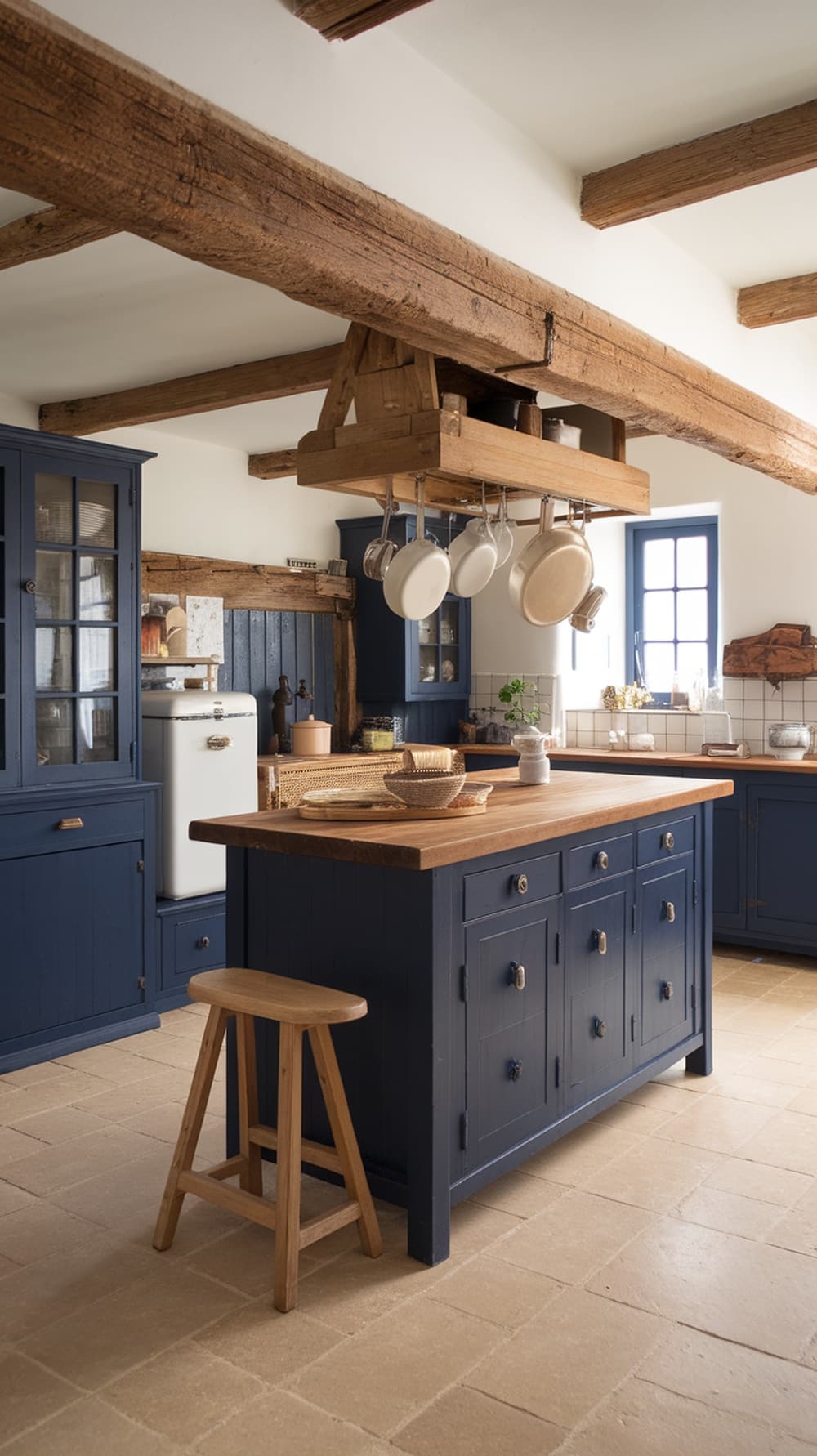 A modern kitchen featuring navy blue cabinets, wooden beams, and a rustic island.
