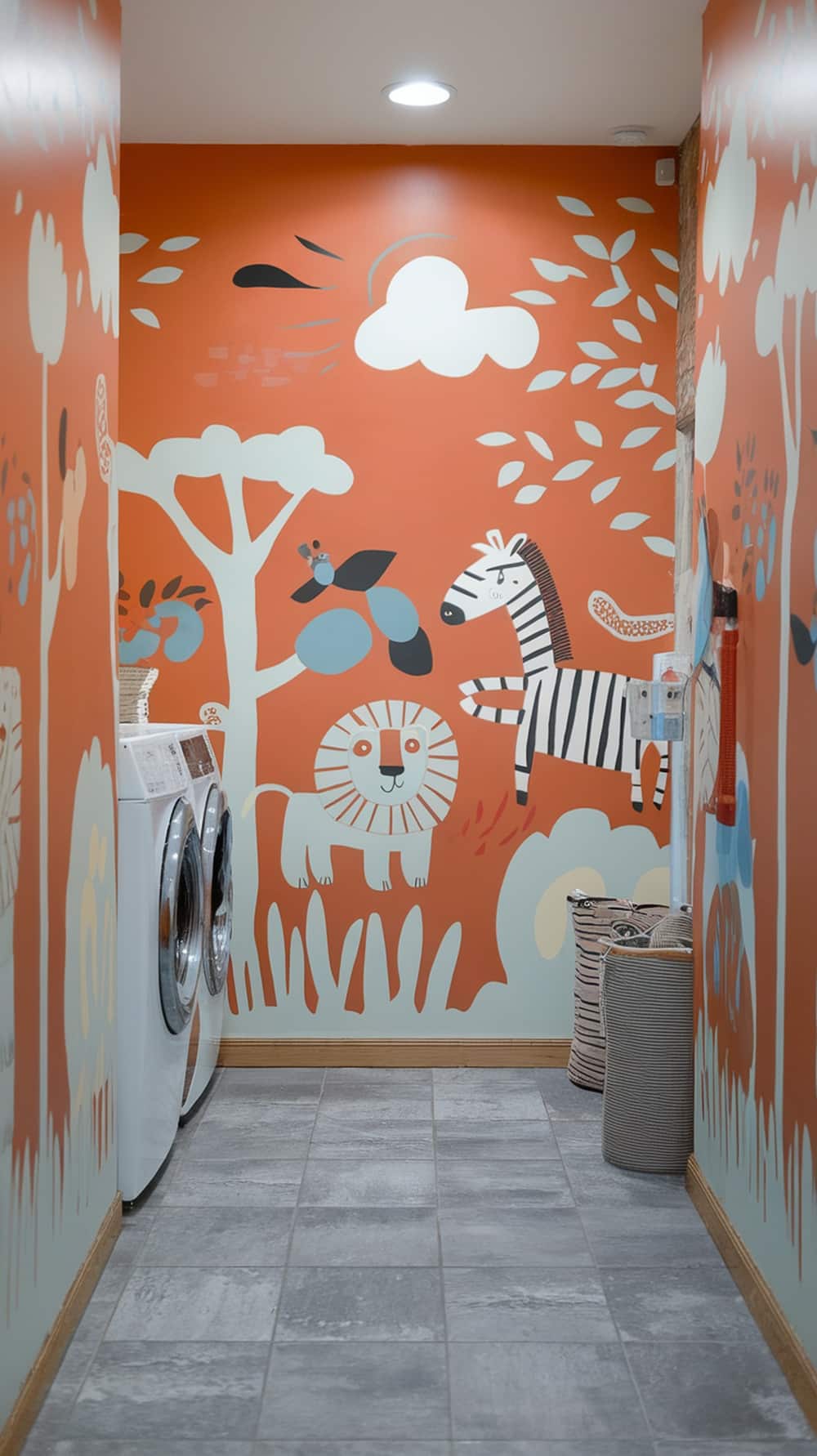 A laundry room with a whimsical orange mural featuring animals like a lion and a zebra, surrounded by trees and clouds.
