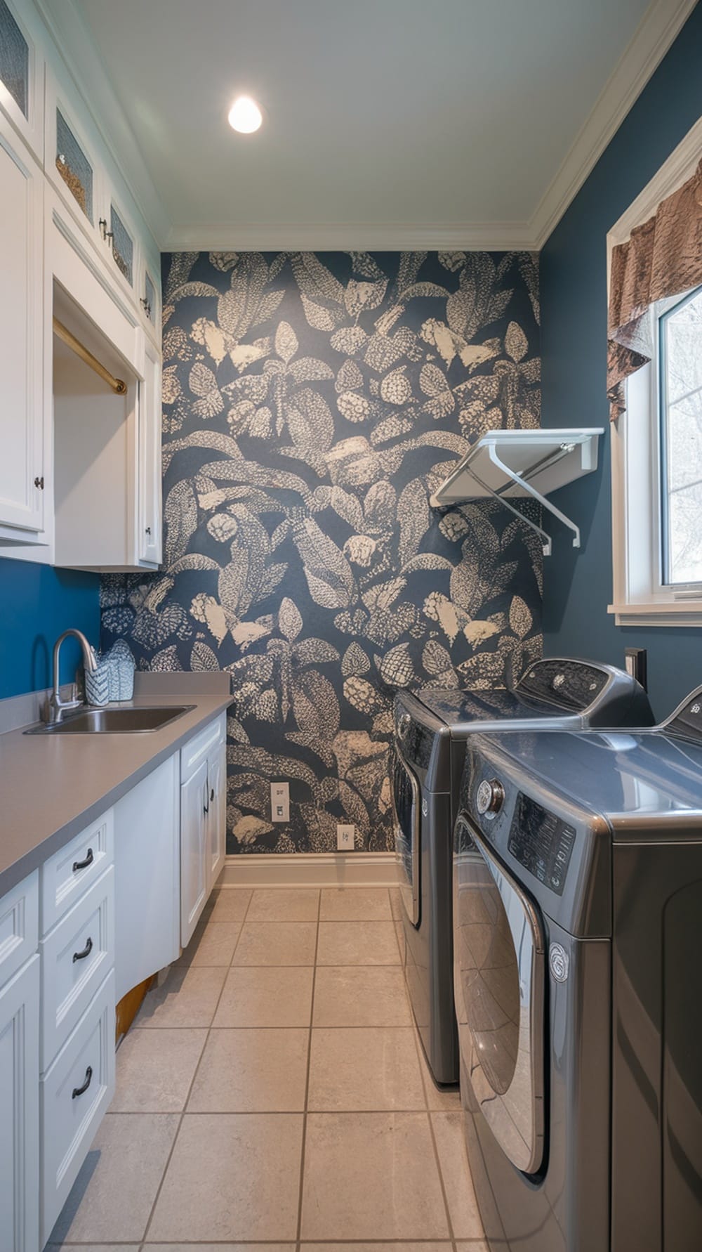 Laundry room with slate blue accent wall and leaf-patterned wallpaper